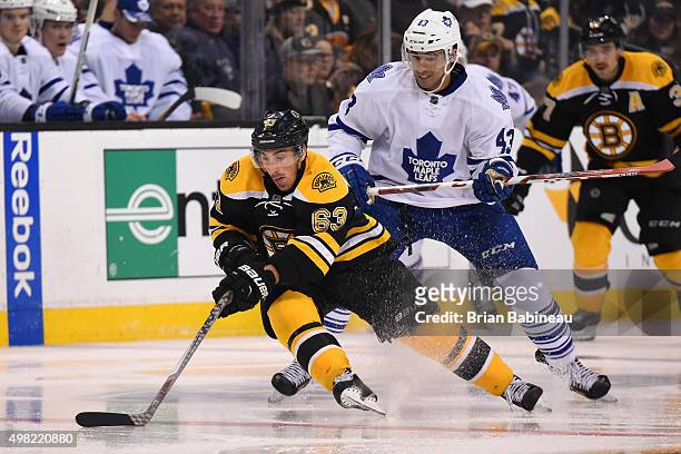 Brad Marchand of the Boston Bruins skates with the puck against Nazem Kadri of the Toronto Maple Leafs at the TD Garden on November 21, 2015 in...