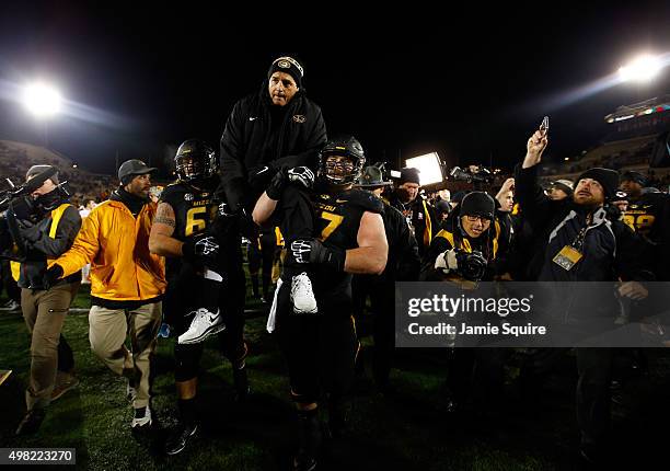 Head coach Gary Pinkel of the Missouri Tigers is carried off the field by offensive lineman Brad McNulty and offensive lineman Evan Boehm after the...