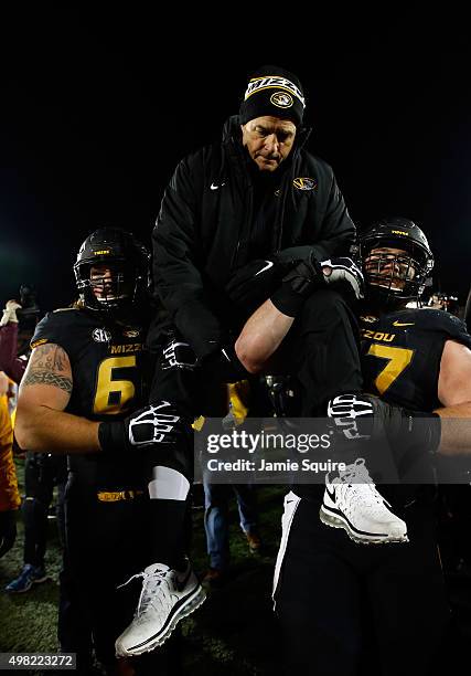 Head coach Gary Pinkel of the Missouri Tigers is carried off the field by offensive lineman Brad McNulty and offensive lineman Evan Boehm after the...