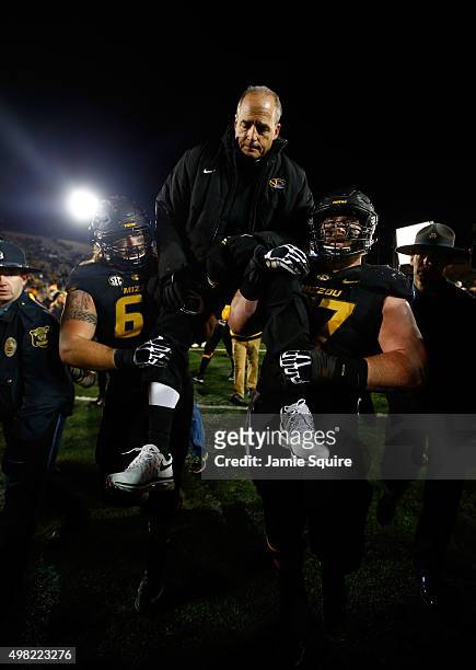 Head coach Gary Pinkel of the Missouri Tigers is carried off the field by offensive lineman Brad McNulty and offensive lineman Evan Boehm after the...