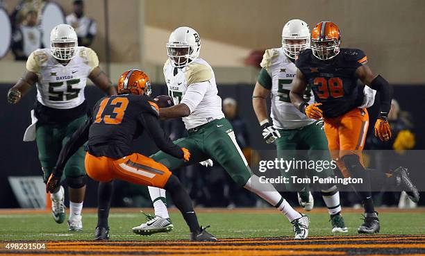 Chris Johnson of the Baylor Bears carries the ball against Trace Clark of the Oklahoma State Cowboys and Jordan Sterns of the Oklahoma State Cowboys...