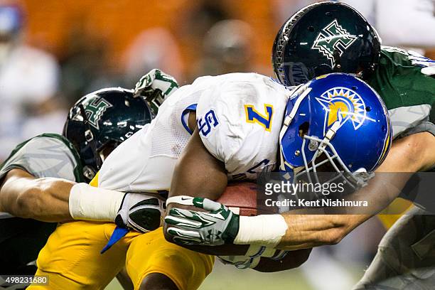 Tyler Ervin of the San Jose State Spartans is stopped by Simon Poti and Julian Gener of the Hawaii Warriors during the first quarter of a college...