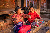 Two Nepali women  spinning a wool in Bhaktapur, Nepal