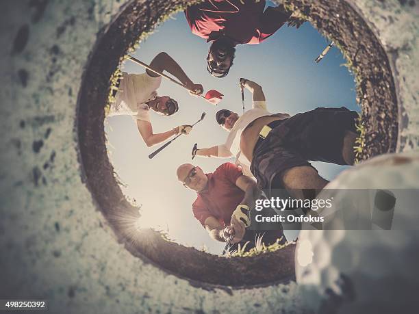 point of view golf players and ball from inside hole - golf excitement stock pictures, royalty-free photos & images