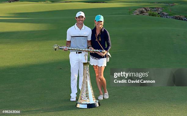 Rory McIlroy of Northern Ireland poses with his girlfriend Erica Stoll and the DP World Tour Championship and Race to Dubai trophy after his one shot...