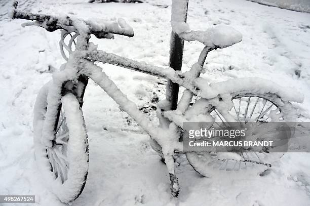 Bike parked on November 22, 2015 in Hamburg, northern Germany is coverd in snow. AFP PHOTO / DPA / MARCUS BRANDT +++ GERMANY OUT +++