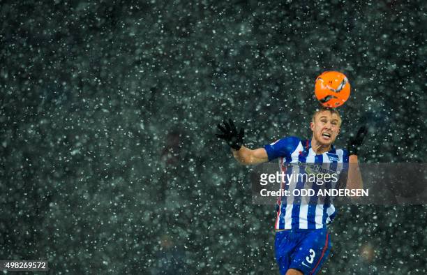 Hertha Berlin's Norwegian midfielder Per Skjelbred heads the ball in heavy snowfall during the German first division Bundesliga football match Hertha...