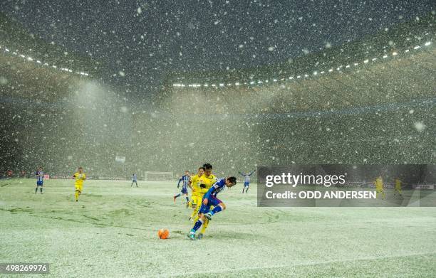 Hertha Berlin's Japanese midfielder Genki Haraguchi and Hoffenheim's Korean defender Jin-Su Kim vie for the ball in heavy snow during the German...