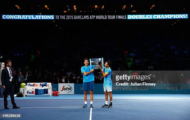 Horia Tecau of Romania and Jean-Julien Rojer of France lift the trophy following their victory during the men's doubles final against Rohan Bopanna...