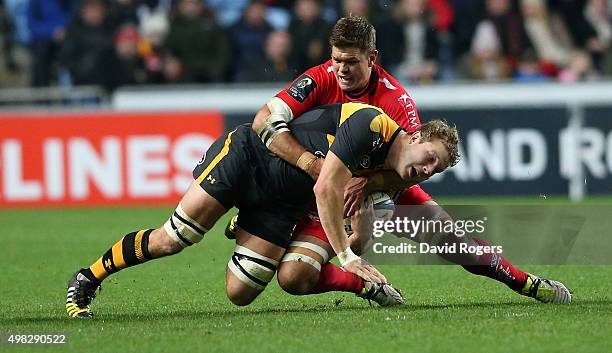 Joe Launchbury of Wasps is tackled by Juan Smith during the European Rugby Champions Cup match between Wasps and Toulon at the Ricoh Arena on...