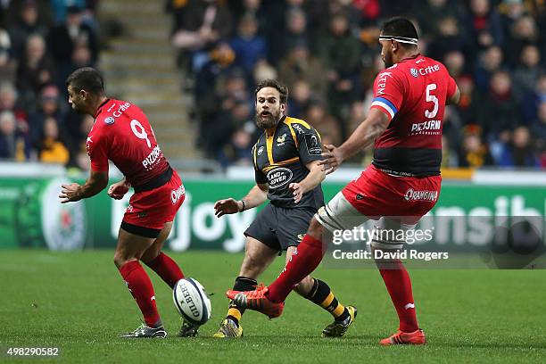 Ruaridh Jackson of Wasps kicks the ball past Jonathan Pelissie and Romain Taofifenua during the European Rugby Champions Cup match between Wasps and...