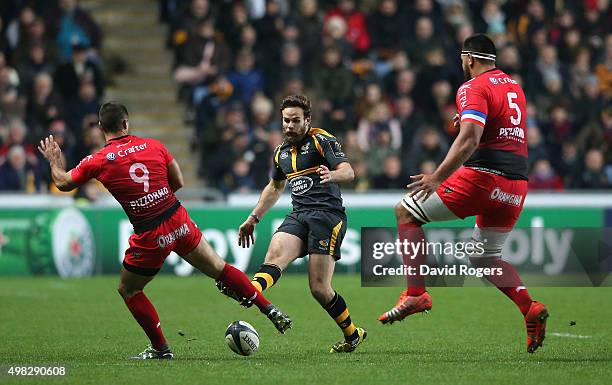 Ruaridh Jackson of Wasps kicks the ball past Jonathan Pelissie and Romain Taofifenua during the European Rugby Champions Cup match between Wasps and...