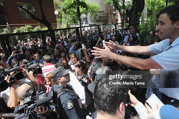 Onlookers and media members attempt to catch a glimpse outside the polling station where candidate Mauricio Macri voted on November 22, 2015 in...