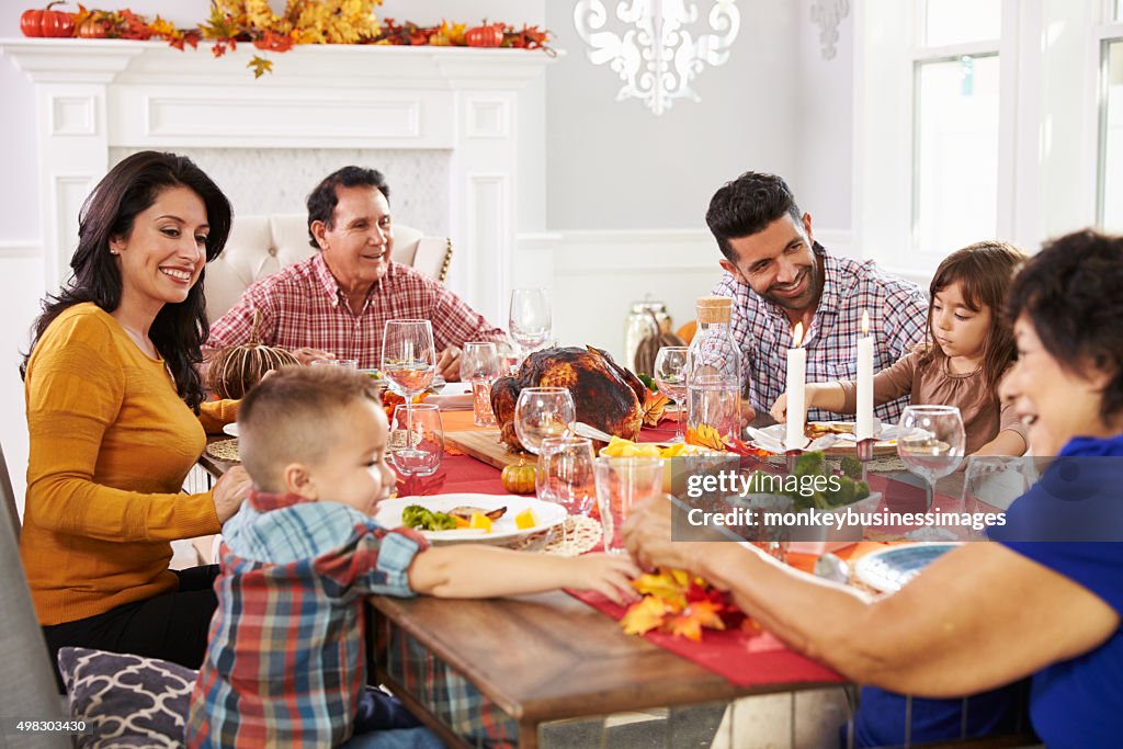 Family With Grandparents Enjoying Thanksgiving Meal At Table