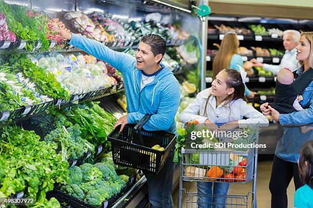 parents purchasing fresh produce in grocery store with kids - sportswear shop stock pictures, royalty-free photos & images