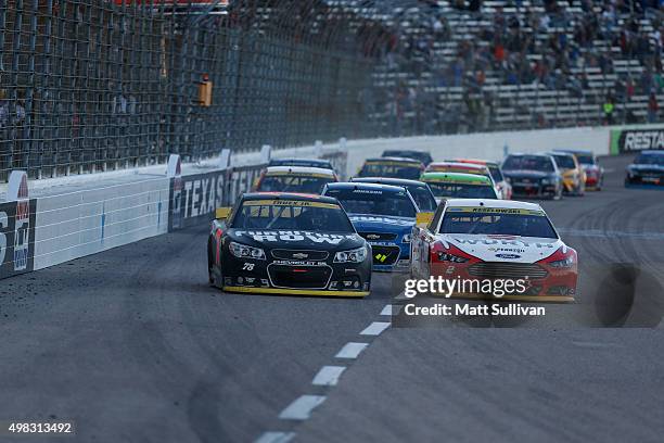 Martin Truex Jr., driver of the Furniture Row/Visser Precision Chevrolet, races with Brad Keselowski, driver of the Wurth Ford, during the NASCAR...