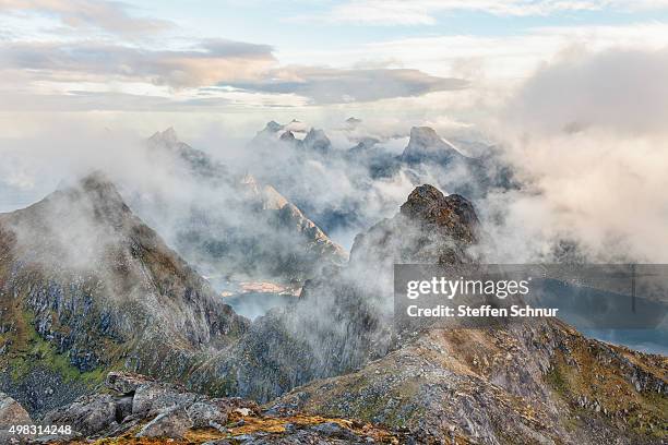 clouds between the peaks of the lofoten, norway - moskenesoya stock pictures, royalty-free photos & images