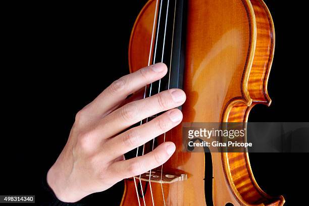 hand touching the strings of the violin - violino stockfoto's en -beelden