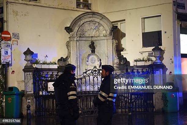 Belgian police officers stand guard near the Manneke Pis fountain in Brussels on November 22, 2015. Brussels will remain at the highest possible...