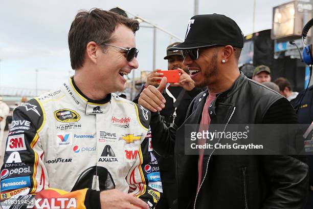 Jeff Gordon, driver of the AXALTA Chevrolet, walks with Formula One World Champion Lewis Hamilton during pre-race ceremonies for the NASCAR Sprint...