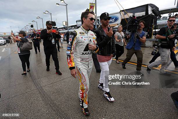 Jeff Gordon, driver of the AXALTA Chevrolet, walks with Formula One World Champion Lewis Hamilton during pre-race ceremonies for the NASCAR Sprint...