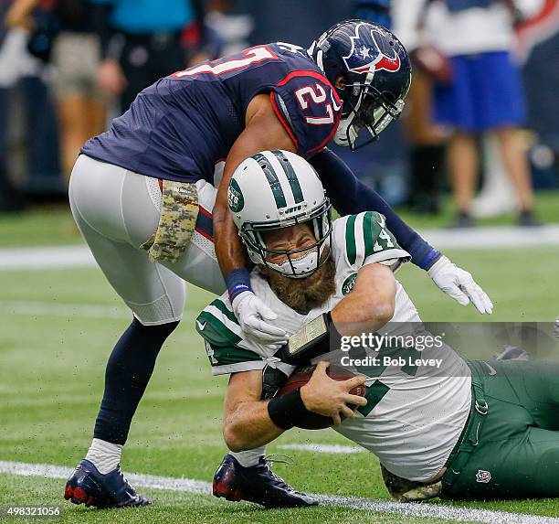 Ryan Fitzpatrick of the New York Jets loses his helmet after taking a hit to the head from Quintin Demps of the Houston Texans in the fourth quarter...