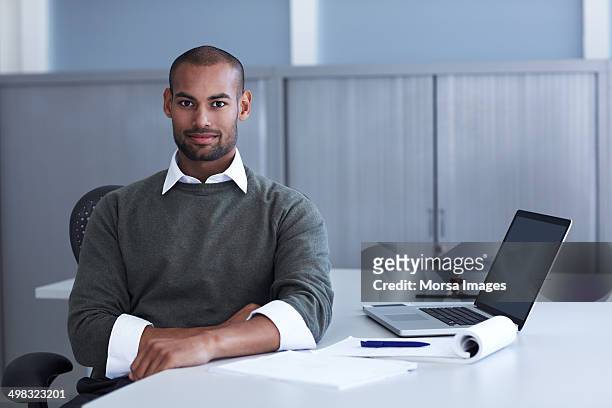 portrait of confident businessman at desk - sweater stockfoto's en -beelden