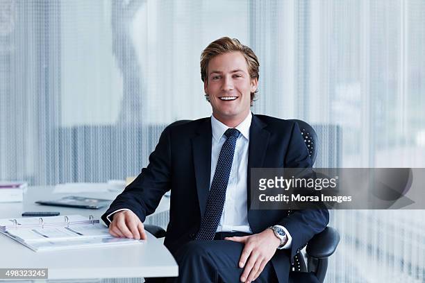 handsome businessman sitting at desk - suit and tie stock pictures, royalty-free photos & images