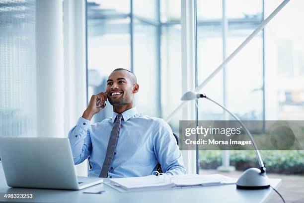 smiling businessman using mobile phone at desk - business person on phone stock pictures, royalty-free photos & images