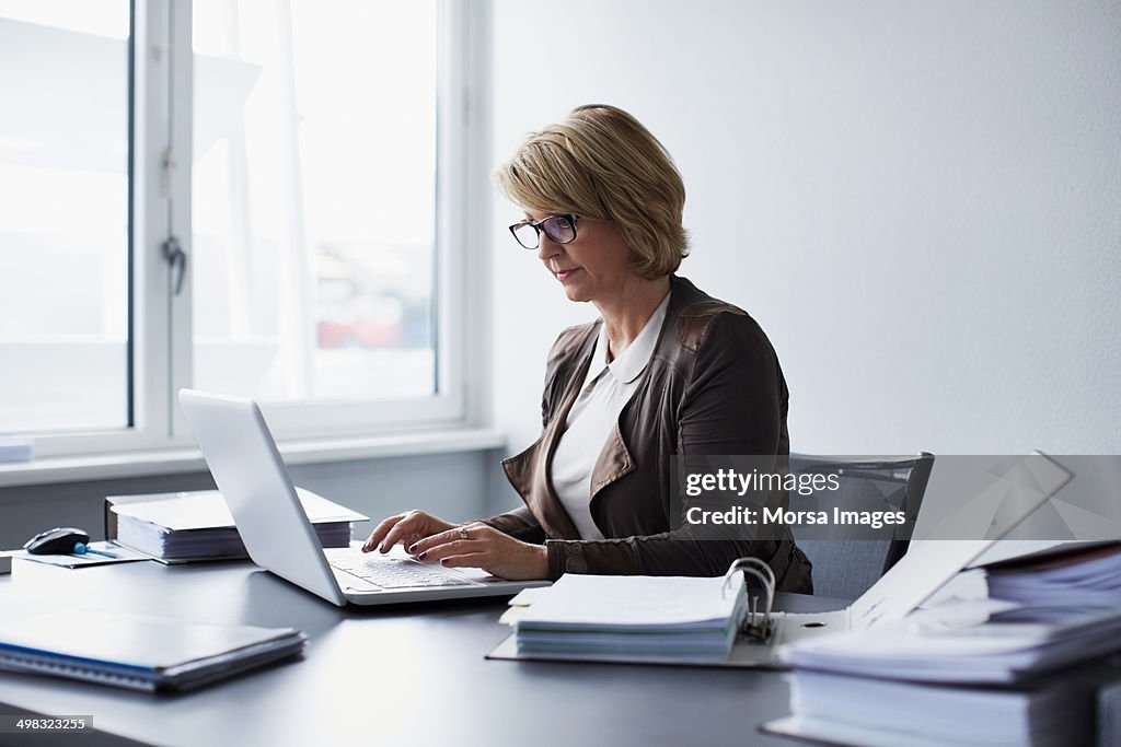 Businesswoman using laptop in office
