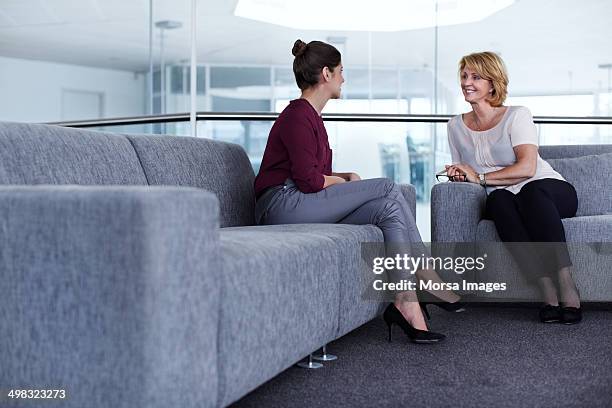 businesswomen having casual discussion - gray pants photos et images de collection