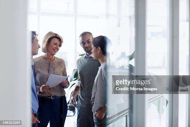 businesswoman discussing with colleagues - discussion stock-fotos und bilder