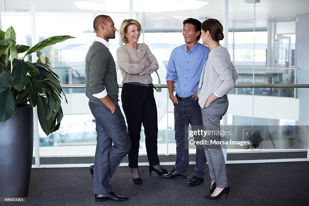Happy businesspeople conversing in office