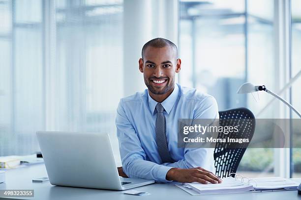 portrait of happy businessman at desk - homem de azul imagens e fotografias de stock