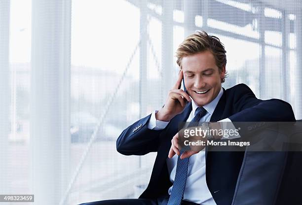 businessman checking time in office - wristwatch stockfoto's en -beelden