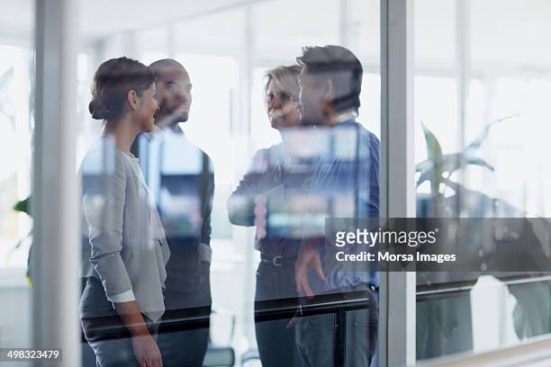 businesspeople conversing in office - four people foto e immagini stock