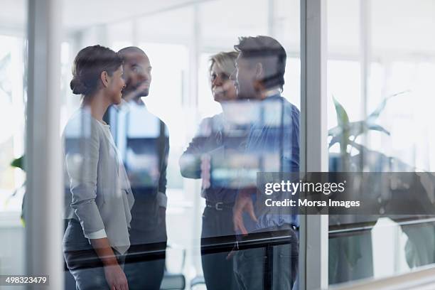 businesspeople conversing in office - reflection glass stock pictures, royalty-free photos & images