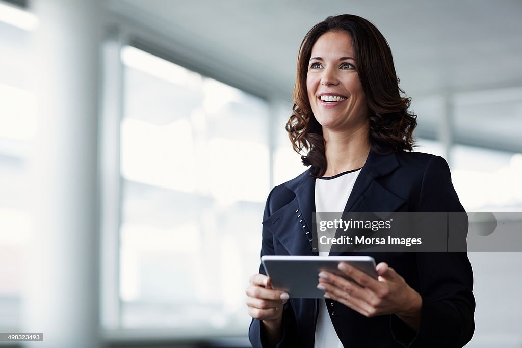 Happy businesswoman holding digital tablet