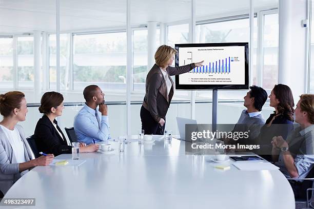 businesswoman giving presentation in meeting - apresentar imagens e fotografias de stock