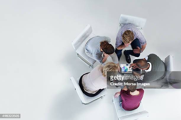 businesspeople using digital tablet together - overhead view foto e immagini stock