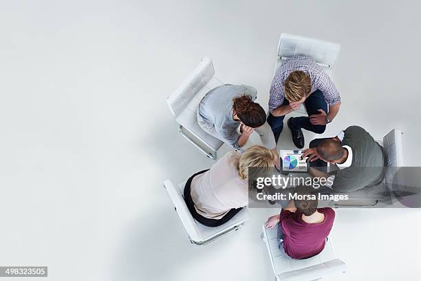 businesspeople using digital tablet together - human cooperation stock pictures, royalty-free photos & images