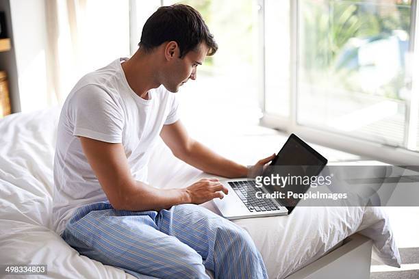 checking his emails in the morning - pyjamas stock pictures, royalty-free photos & images