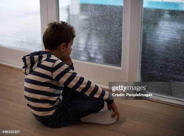 rainy days with nothing to do... - boy sitting on floor stock pictures, royalty-free photos & images