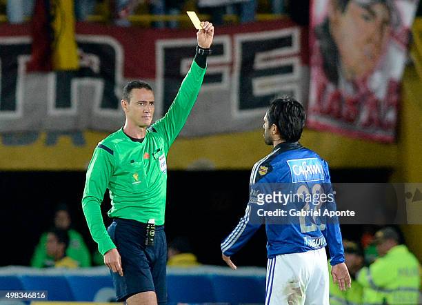 Referee Wilmar Roldan shows the yellow card to Fabian Vargas of Millonarios during a match between Millonarios and Independiente Santa Fe as part of...