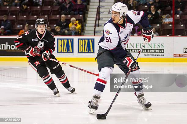 Defenceman Jalen Chatfield of the Windsor Spitfires moves the puck against forward Mikkel Aagaard of the Niagara Ice Dogs on November 22, 2015 at the...