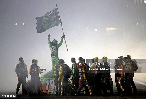 Kyle Busch, driver of the M&M's Crispy Toyota, celebrates with his crew after winning the series championship and the NASCAR Sprint Cup Series Ford...