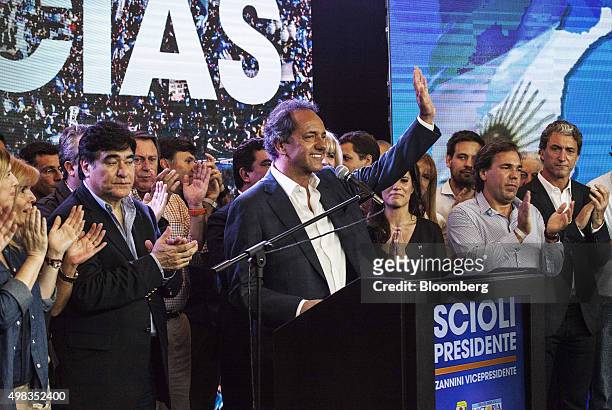 Daniel Scioli, presidential candidate for the ruling party, center, waves to supporters at his campaign headquarters in Buenos Aires, Argentina, on...