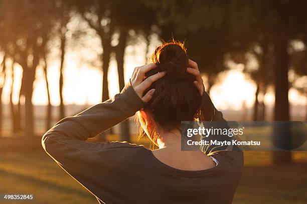 chica contraluz moño - moño stockfoto's en -beelden