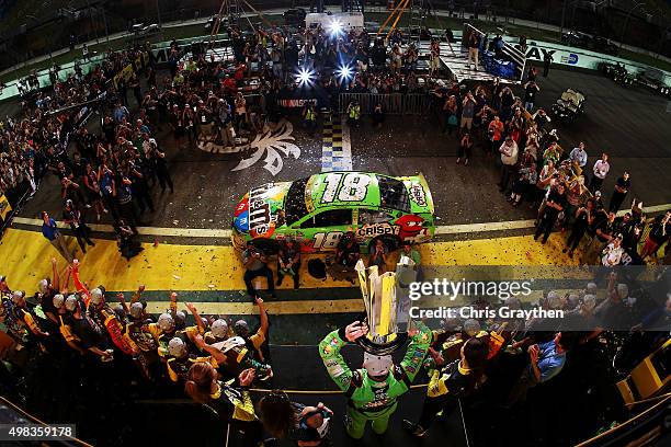 Kyle Busch, driver of the M&M's Crispy Toyota, celebrates with his son Brexton and wife Samantha in Victory Lane after winning the series...