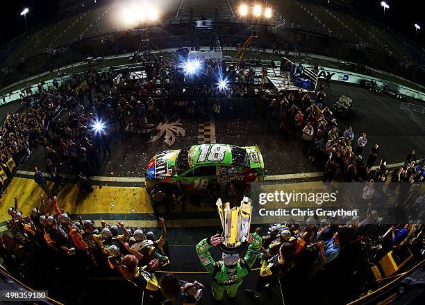 Kyle Busch, driver of the M&M's Crispy Toyota, celebrates with his son Brexton and wife Samantha in Victory Lane after winning the series...